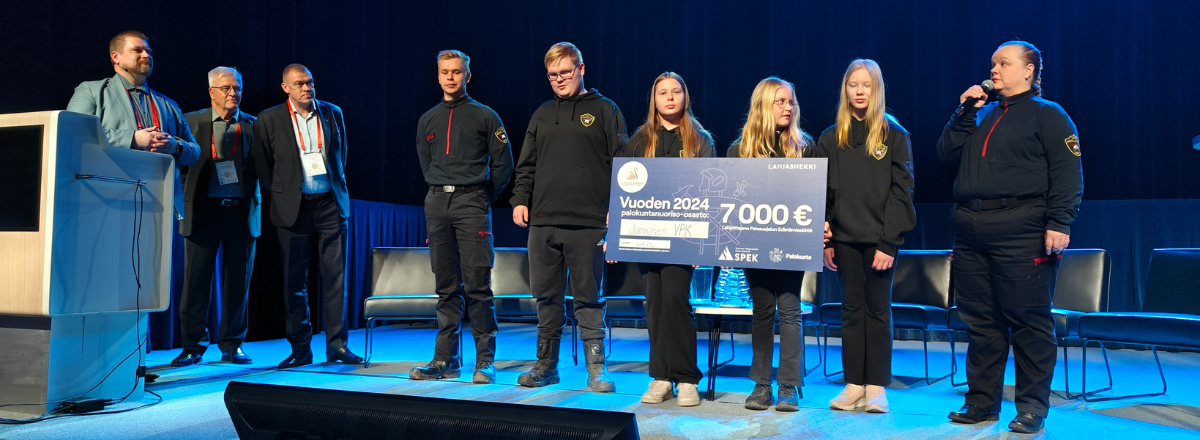 Vuoden palkuntanuoriso-osasto 2024 vastaanottamassa lahjashekkiä Palopäällystöpäivillä